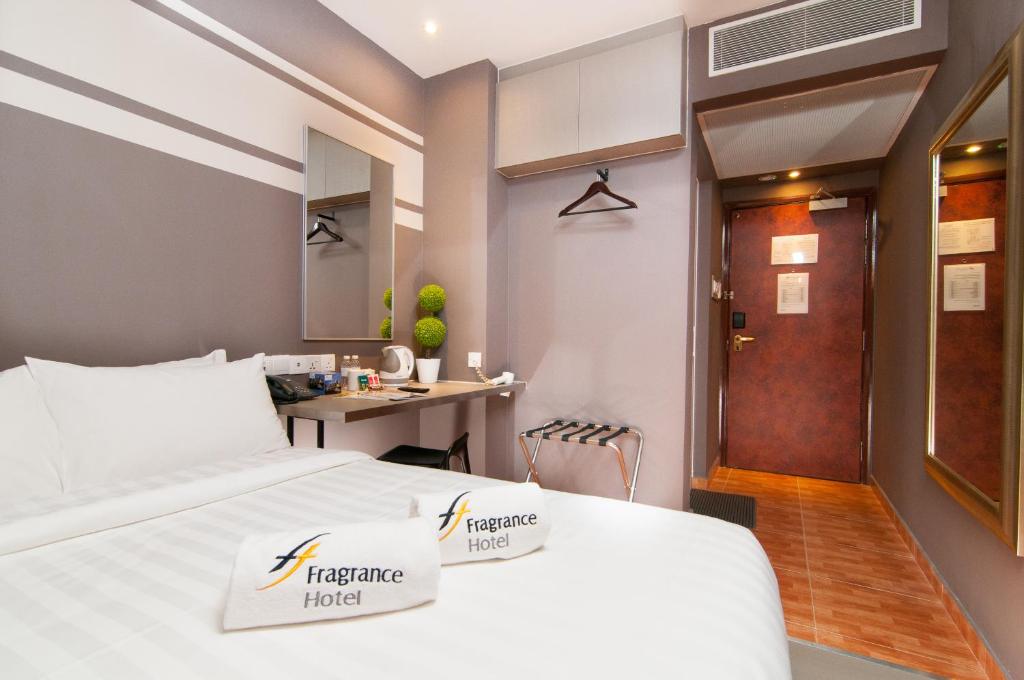 新加坡Fragrance Hotel - Kovan的配有一张床和一张书桌的酒店客房