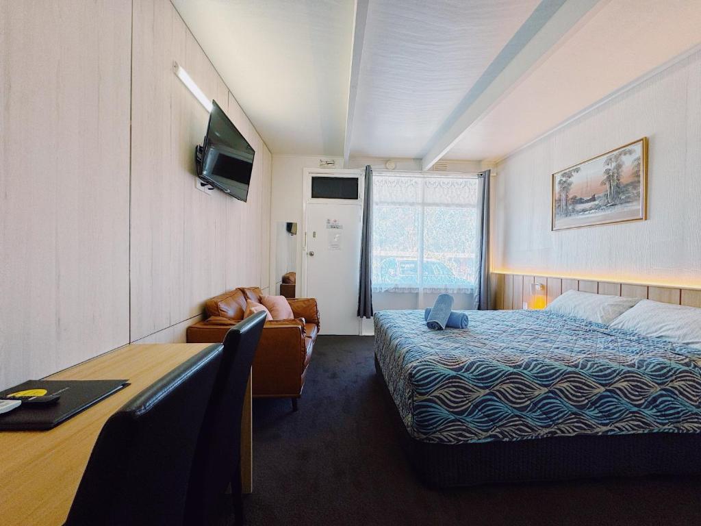 西摩西摩汽车旅馆 的酒店客房配有一张床、一把椅子和一张书桌