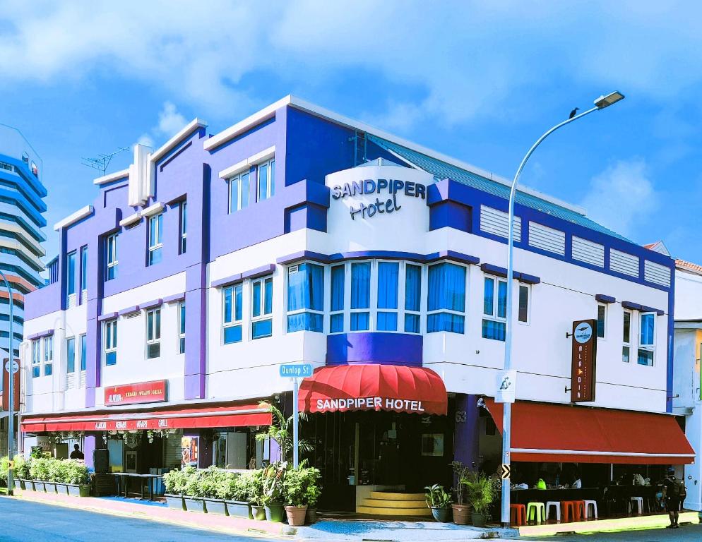 新加坡Sandpiper Hotel Singapore的城市街道上的一座蓝白色建筑