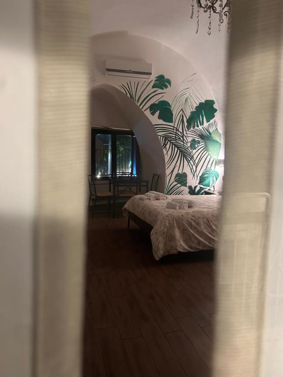 卡塔尼亚大教堂住宿加早餐旅馆的卧室配有一张挂着壁画的床铺
