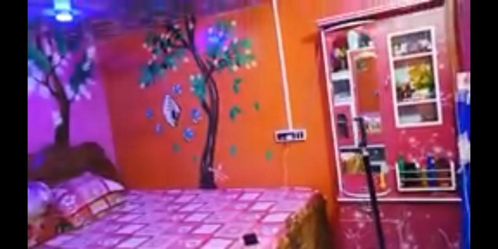 加尔各答Hours home的卧室墙上涂有一棵树