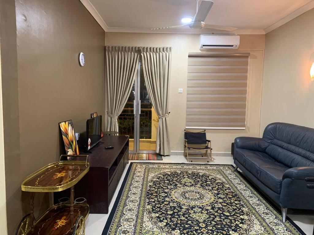 Bandar PenawarDesaru Homestay Southern, Tiara Desaru Seaview Residensi的客厅配有蓝色的沙发和桌子