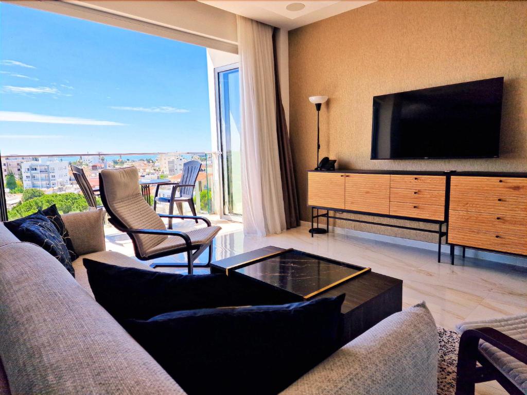 拉纳卡Sveltos Residence Suites的带沙发和电视的客厅