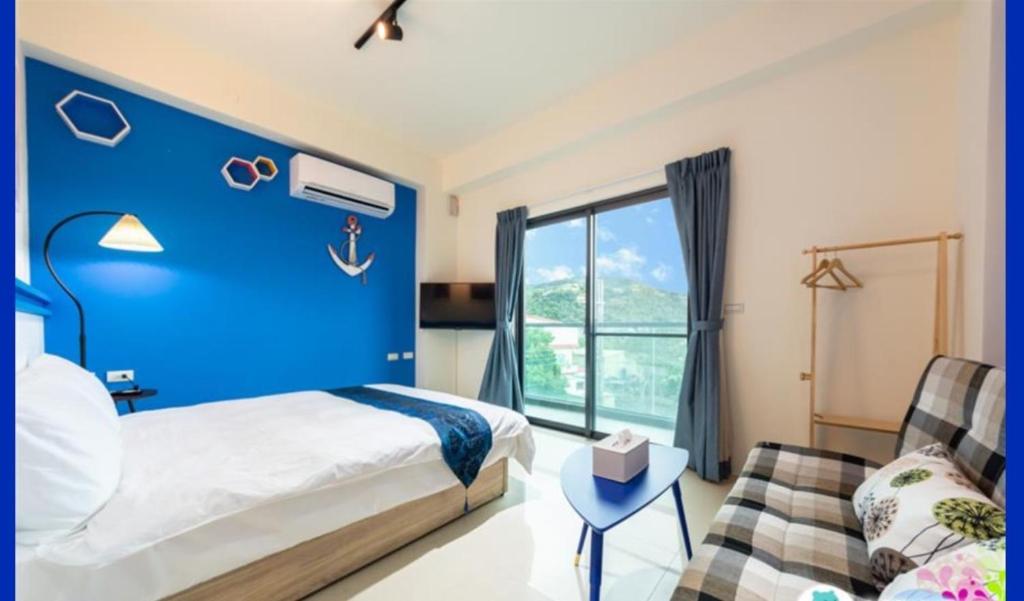 宜蘭曼曼玩民宿的蓝色的卧室配有床和沙发