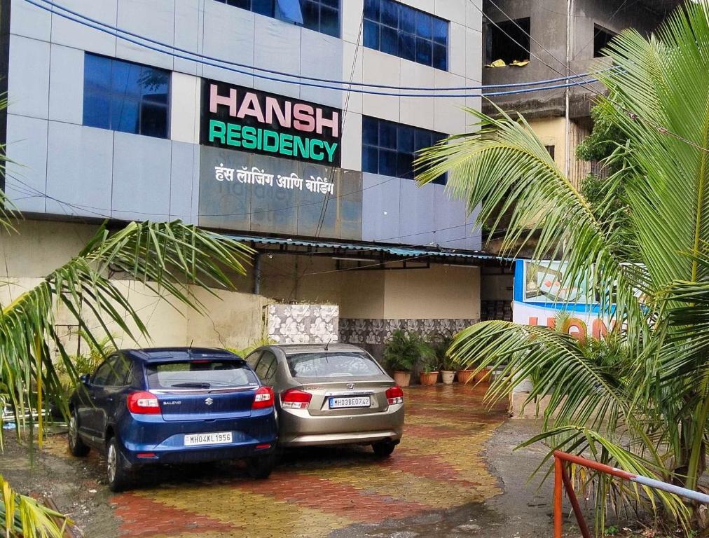 孟买Hansh Residency的两辆汽车停在大楼前的停车场