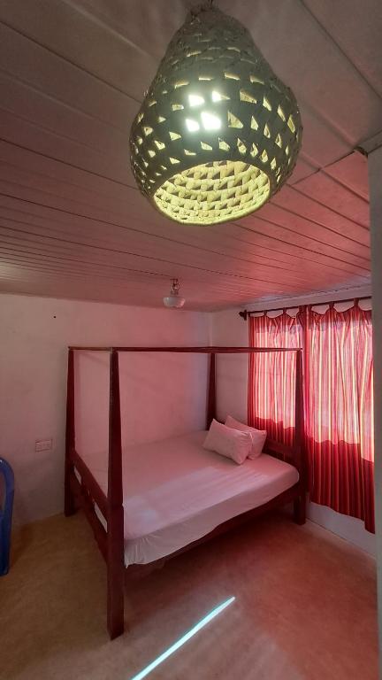 拉穆Roof Top Private House的一张小床,位于一个配有大吊灯的房间