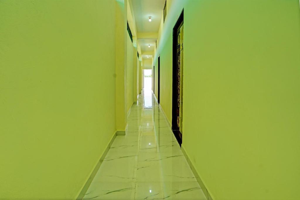 RāipurOYO Flagship Hotel Bliss Inn的一条空洞的走廊,长长的走廊上设有绿色的墙壁