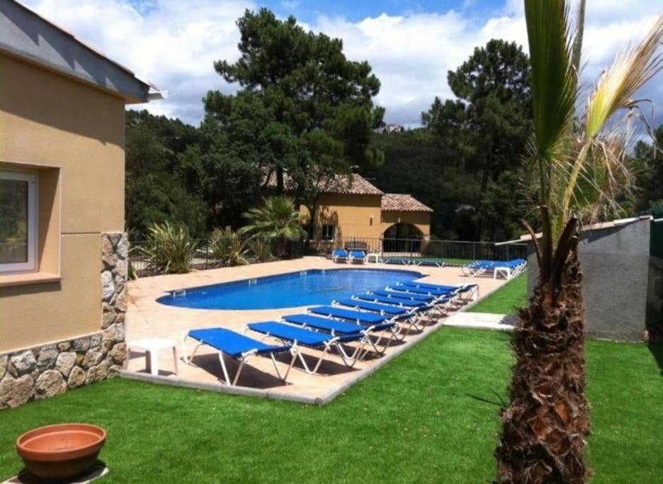 赫罗纳Villa Solimar的一座房子旁的游泳池,配有蓝色躺椅