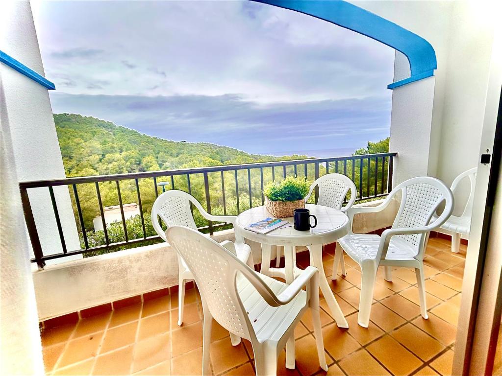 卡拉圣维森特Apartamento en Ibiza的设有一个配有桌椅并享有美景的阳台。