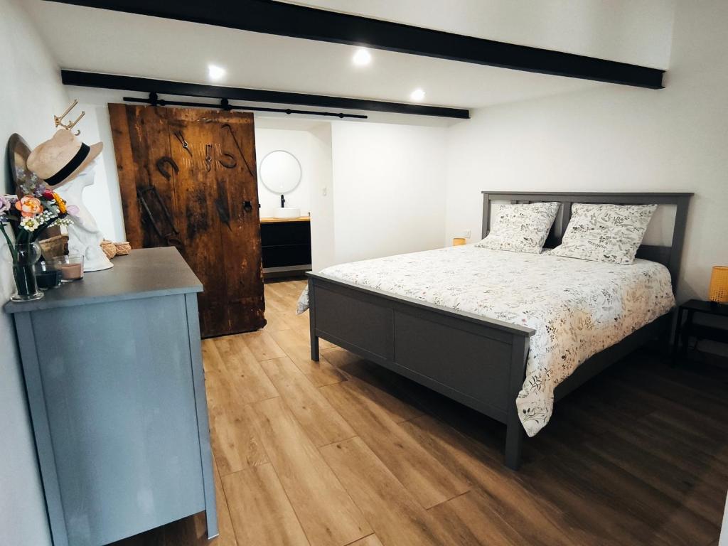 Saint-PrivatGîte de l'atelier的一间卧室配有一张床,铺有木地板