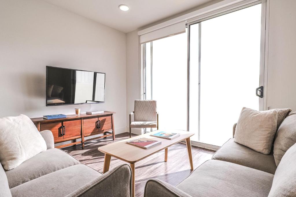 洛杉矶Modern 2BD & 2BTH Santa Monica 5 min to the Pier的客厅配有两张沙发和一台电视机