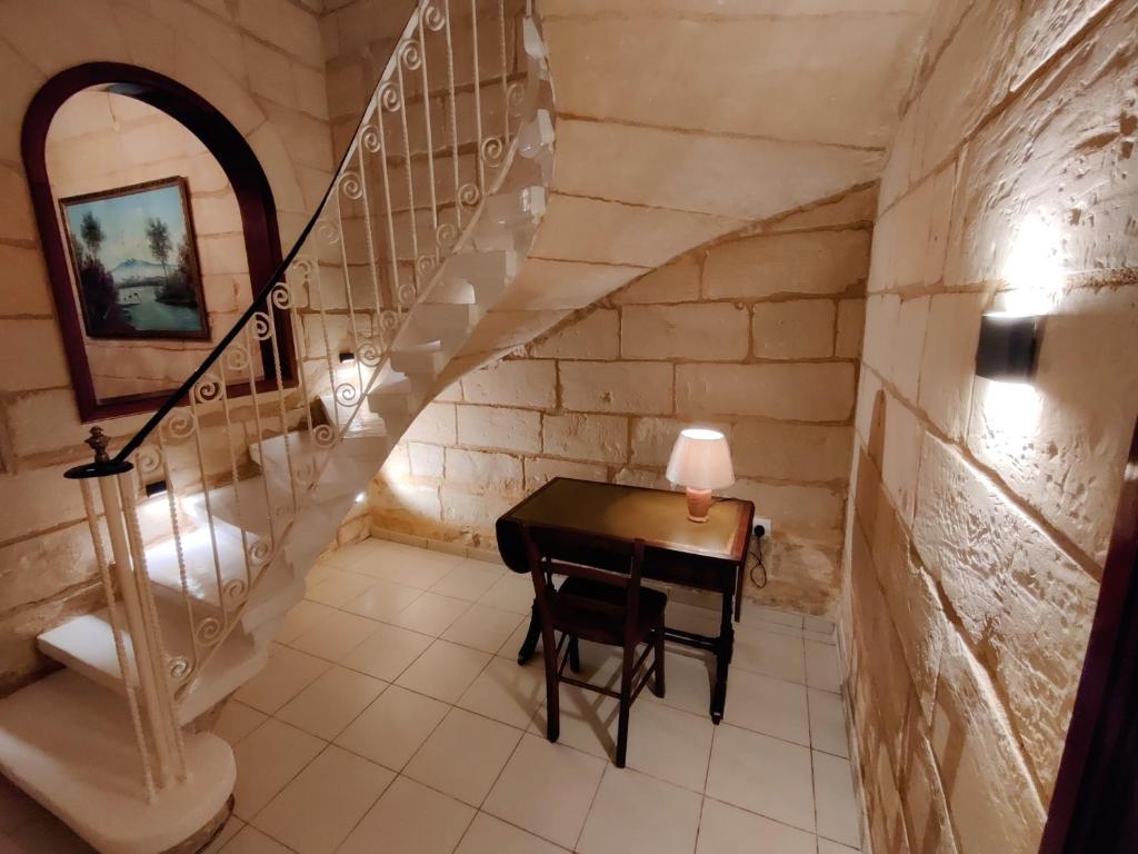 卢加Peaceful Traditional Maltese Townhouse的楼梯间的小桌子