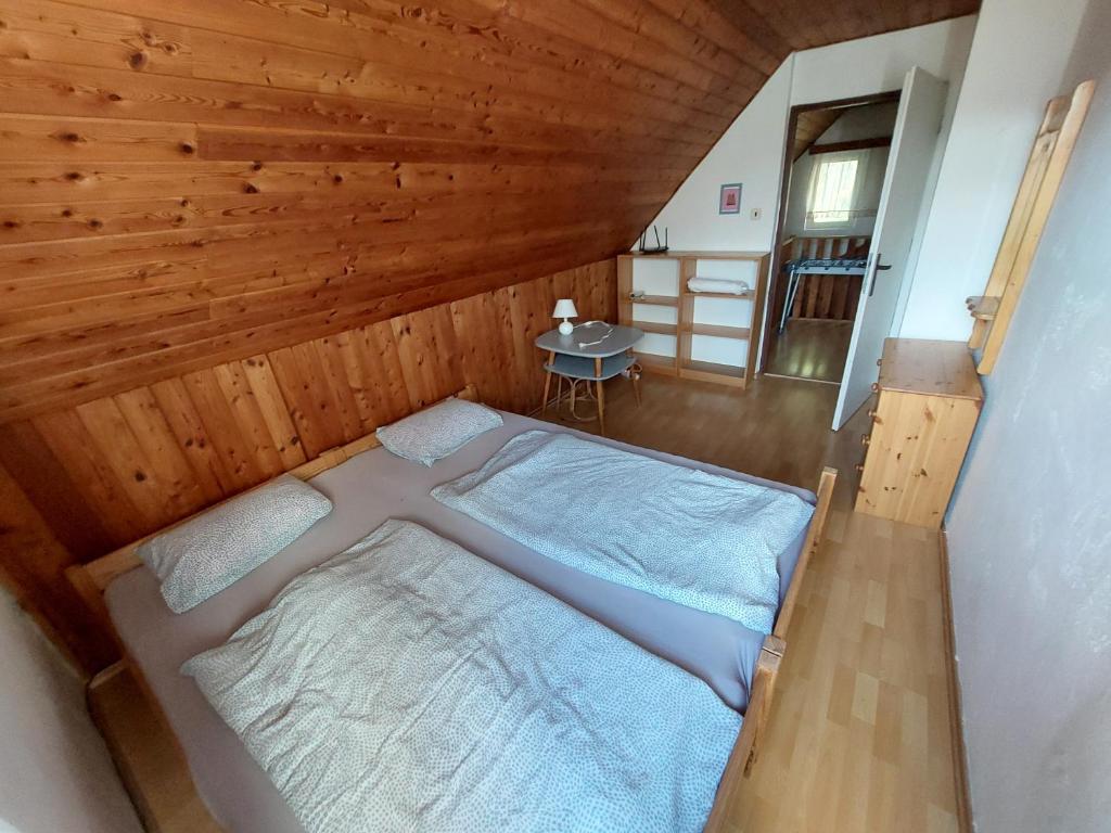 HutiskoChata na Poskle u lesa s výhledem的一张位于带木制天花板的客房内的大床