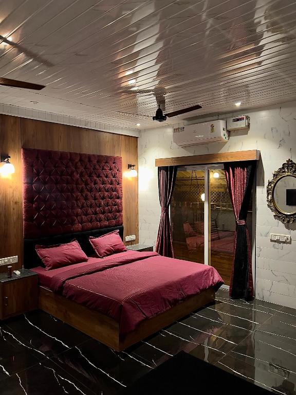 罗纳瓦拉Imagine Love的一间卧室配有一张大床和红色床头板