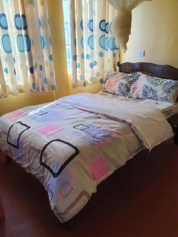 KagioMAGGY LODGE的卧室内的一张带被子的床