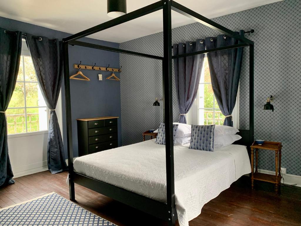 尚塞拉德Brigitte et Moi的一间卧室配有黑色天蓬床和白色床单