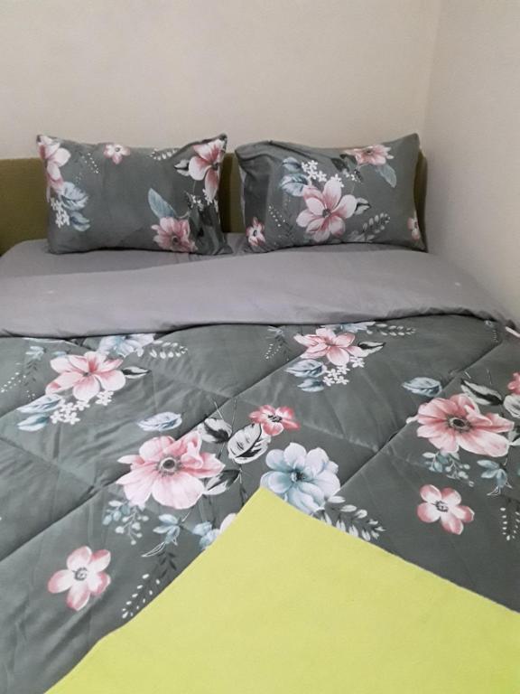 亚的斯亚贝巴Addis Joy Guesthouse的一张床上有粉红色和灰色的花朵