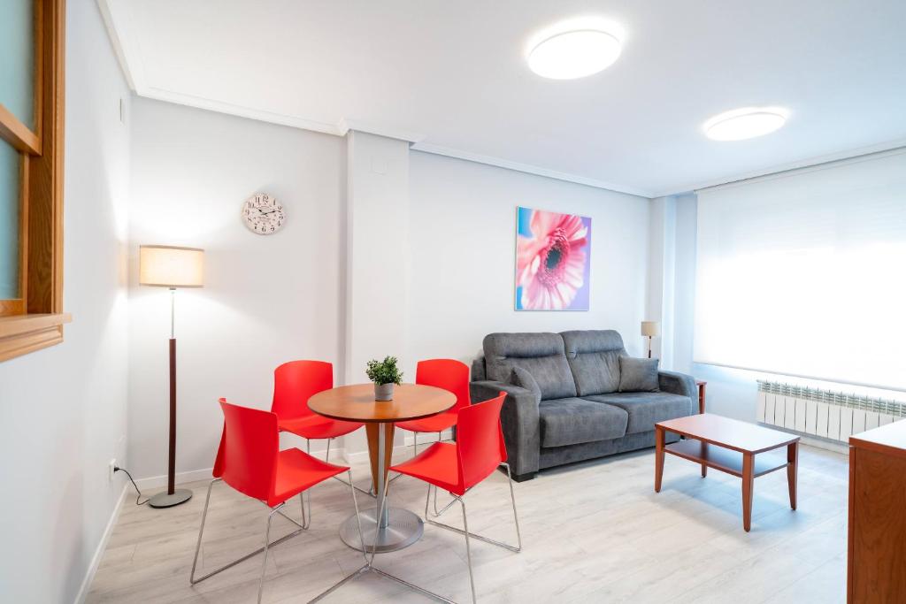巴利亚多利德Apartamentos GO - Génova Parquesol - Parking Gratuito的客厅配有桌椅和沙发