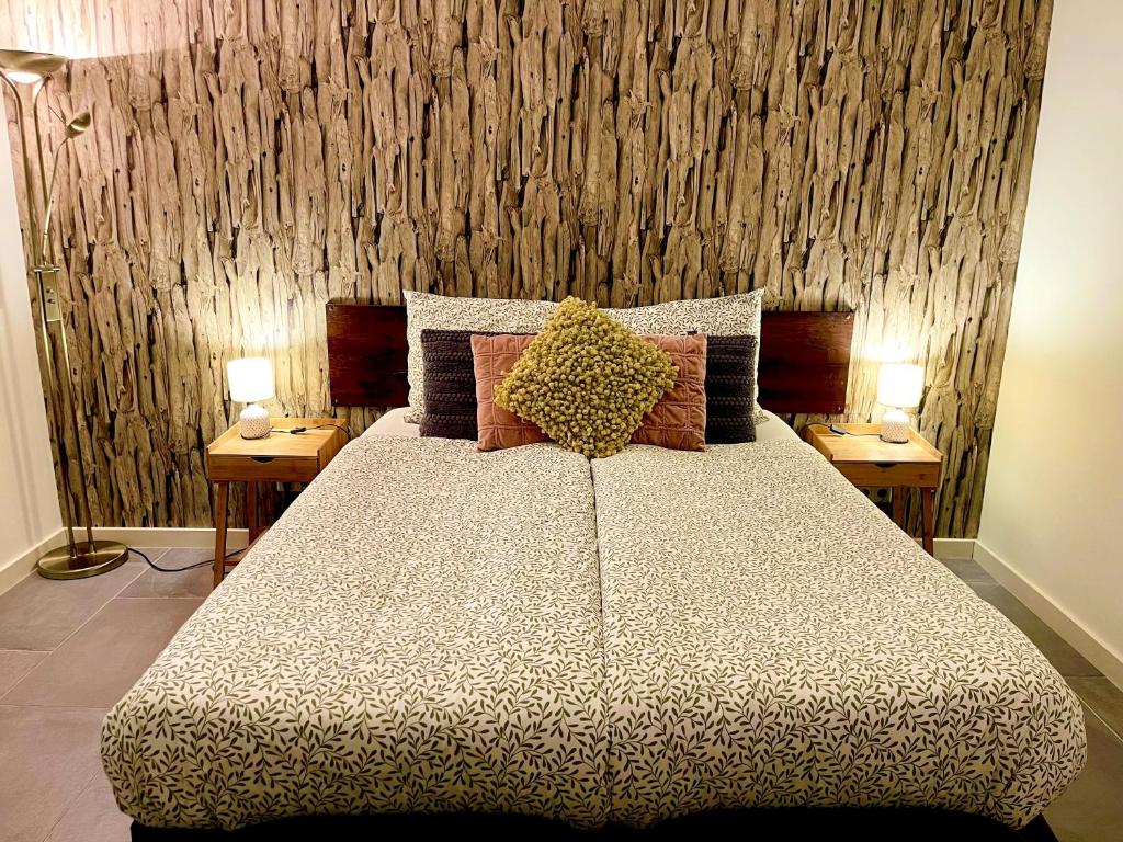 博克斯特尔Gasterij Hotel Dennenoord的一间卧室配有一张大床,桌子上放着两盏灯