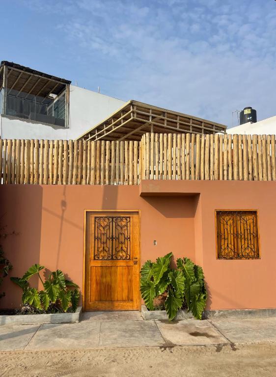 蓬塔赫尔莫萨El Templo Surf House的一座带木门和围栏的房子