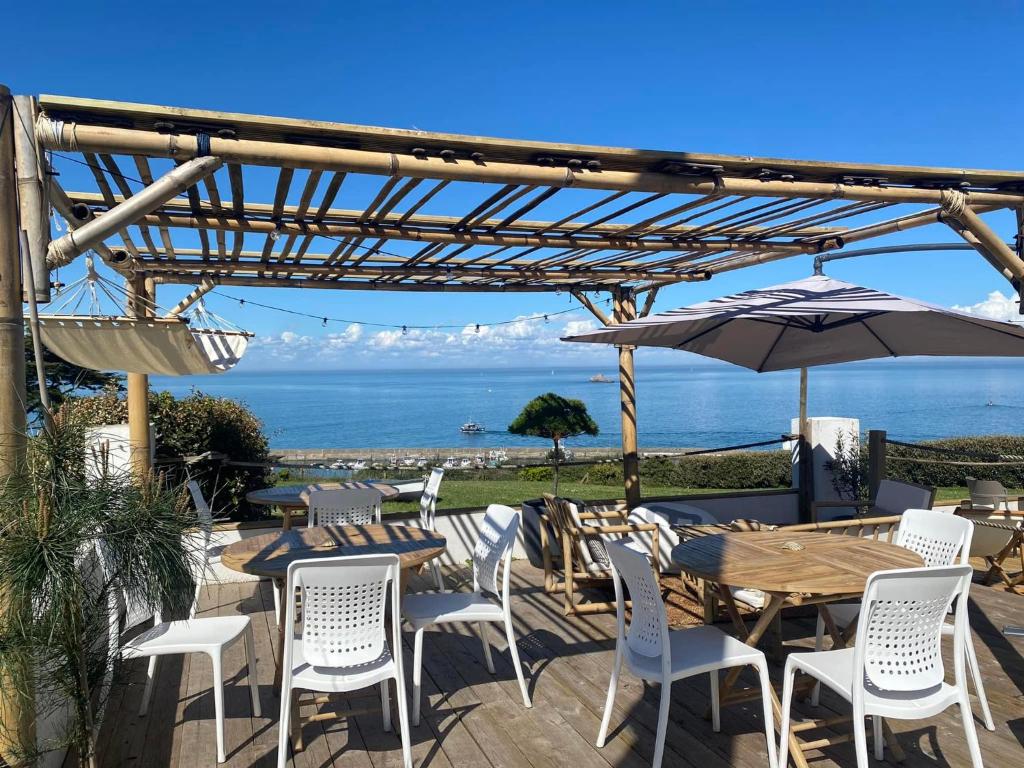 瓦岛Hôtel-Restaurant des Iles的一个带桌椅和遮阳伞的庭院