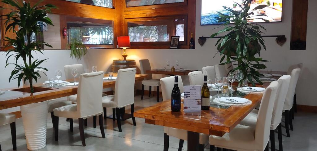 佩斯卡拉Villa Alba Boutique Hotel的用餐室配有木桌和白色椅子