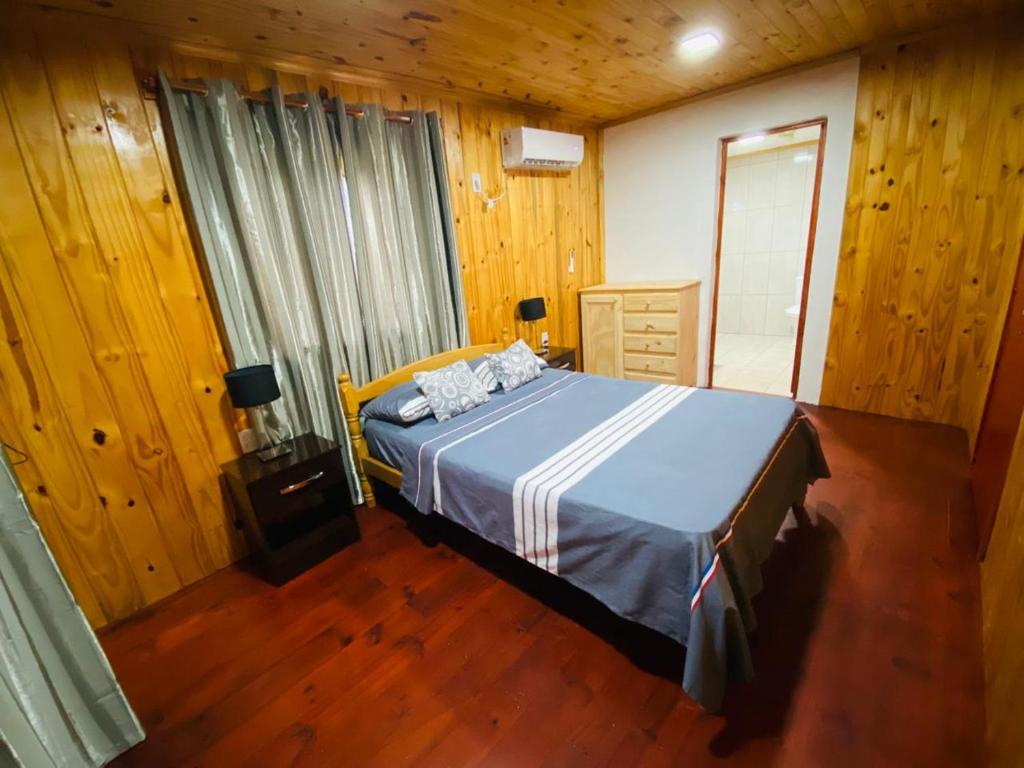 埃尔索韦维奥Alojamiento Matheo的木制客房内的一间卧室,配有一张床