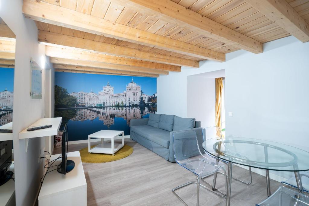 巴利亚多利德Apartamentos GO - Leopoldo Cano Center的客厅配有蓝色的沙发和玻璃桌