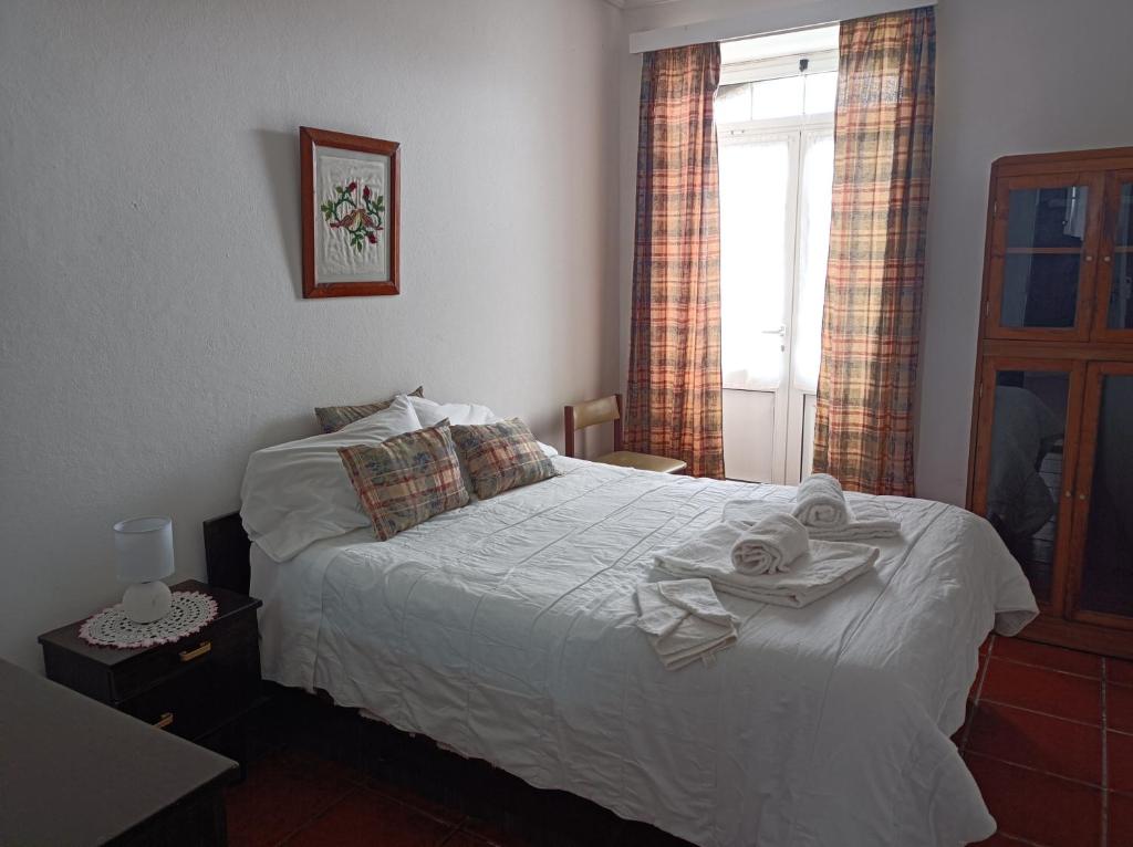 拉日什Rosário Guest House的卧室配有白色床和毛巾