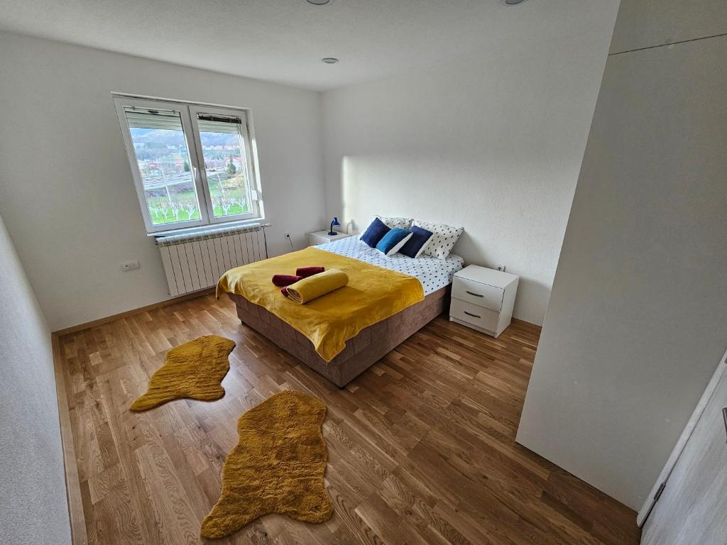 莫伊科瓦茨Ethno Village Adžić的一间卧室配有一张带黄色床单和木地板的床。