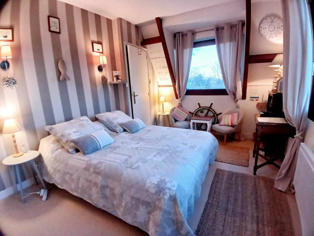 科凯勒Chambres d'Hôtes "Les Pins"的一间卧室设有一张大床和一个窗户。
