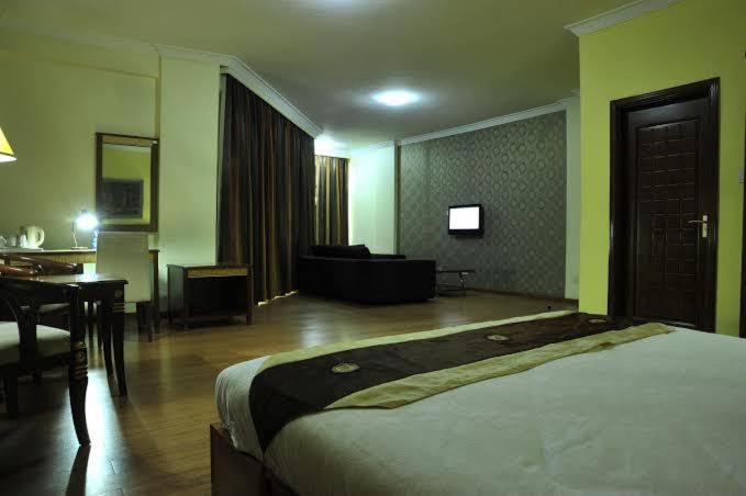 内罗毕Nomad Paradise Hotel的一间卧室设有一张床和一间客厅。