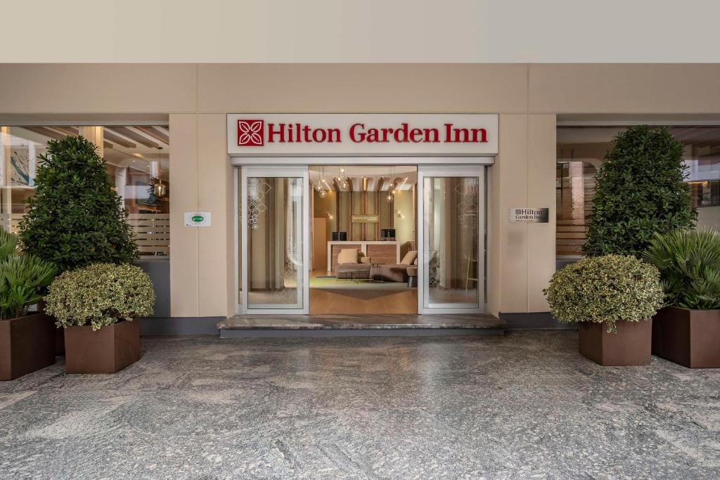 帕多瓦Hilton Garden Inn Padova City Centre的一座拥有100万个花园旅馆的建筑的入口