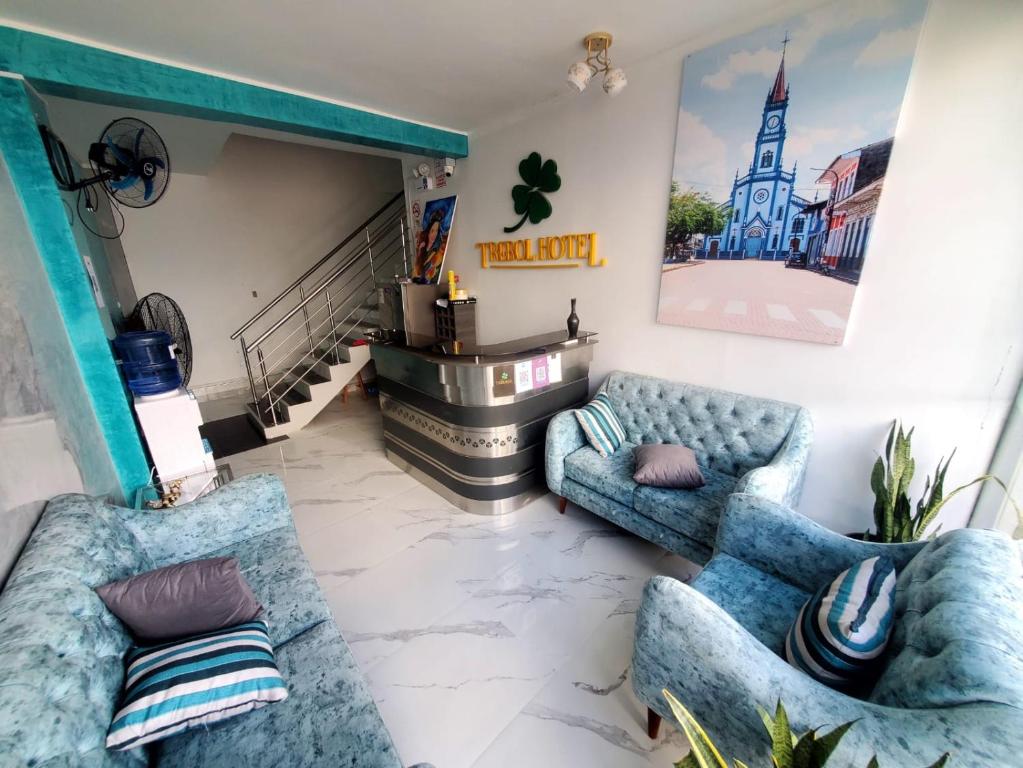 YurimaguasHOTEL EL TREBOL的客厅设有2张蓝色的沙发和楼梯