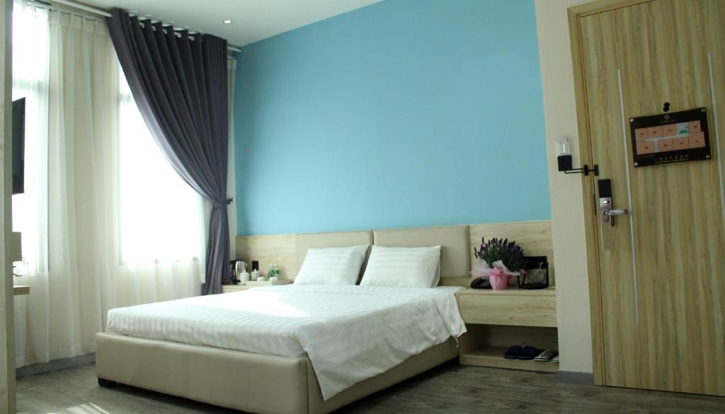 胡志明市Khách sạn Phước Lộc Thọ 2 - 福禄寿的卧室配有白色的床和蓝色的墙壁