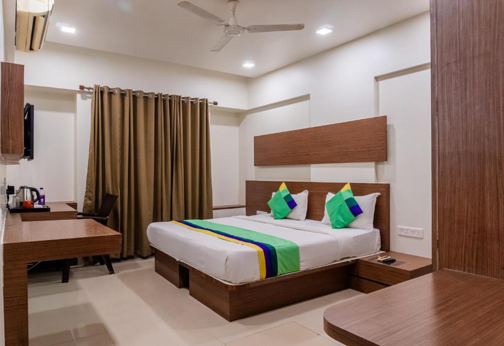 浦那Treebo Trend Blossom - Viman Nagar的配有一张床和一张书桌的酒店客房