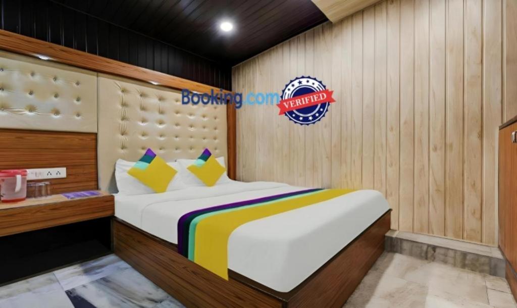 奈尼塔尔Hotel Flatties Mall Road Lake View Nainital的卧室配有一张挂有墙上标志的床