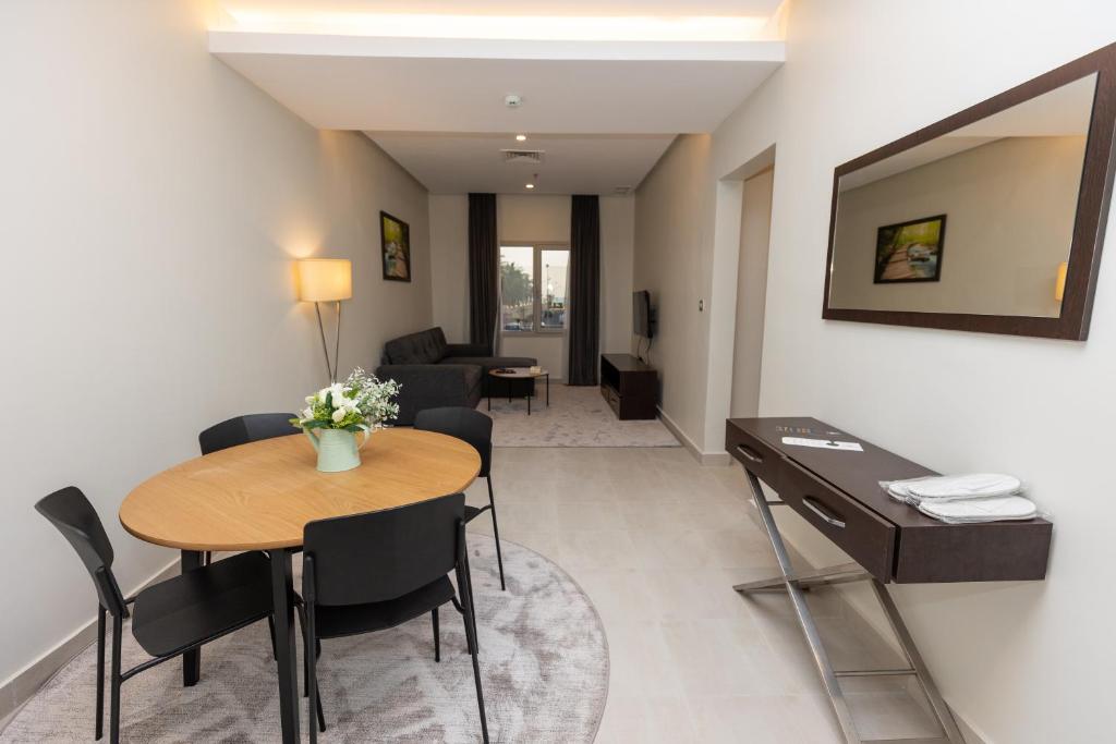 科威特Saray Hotel Apartments的一间客厅,客厅内配有桌椅