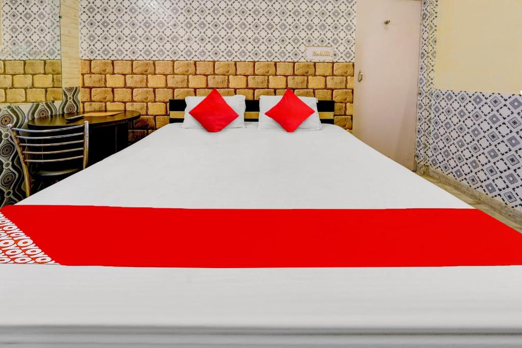巴特那OYO Flagship Hotel Viraasat的一间卧室配有一张带红色枕头的大床