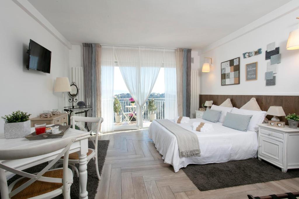 佩鲁贾庞托酒店的白色的卧室设有床、书桌和窗户