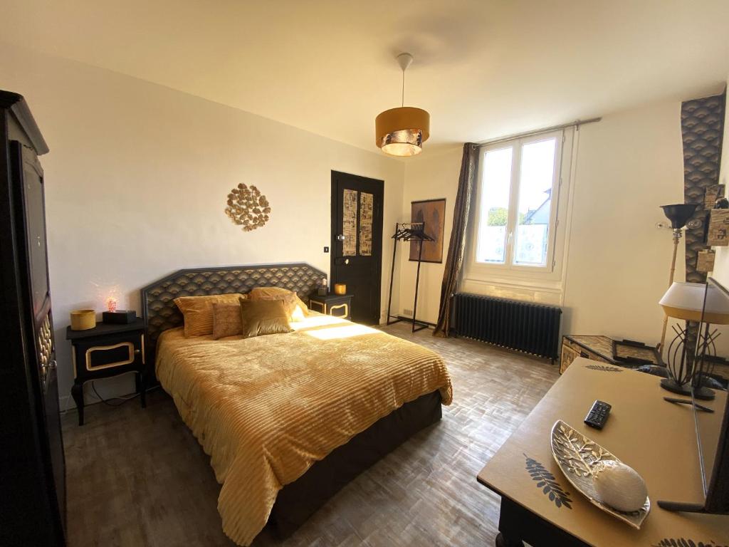 普勒尔蒂Chambre dorée的一间卧室配有一张大床和一张书桌