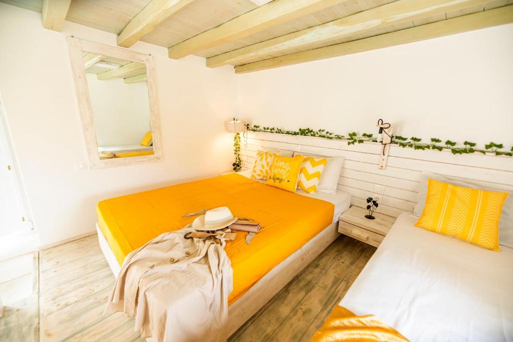 圣斯特凡诺斯Opus apartment的一间卧室配有黄色的床和镜子