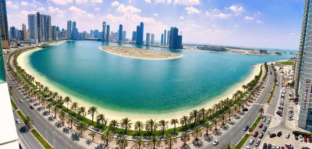 沙迦Luxury Apartment Al Khan Corniche View 2 BD的棕榈树和城市的大片水体