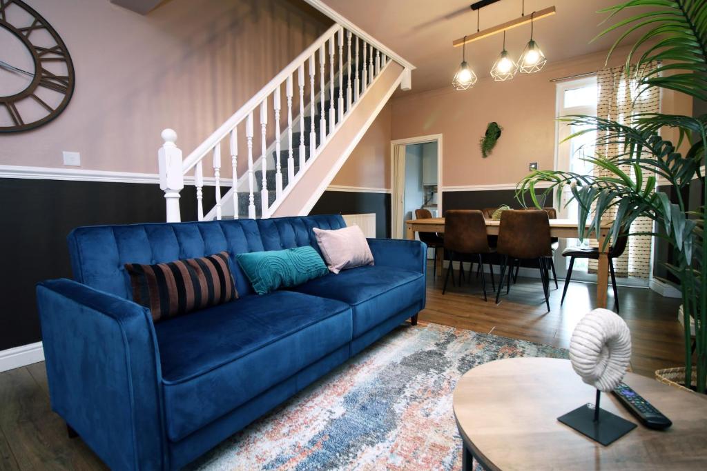 AbertilleryCosy 3BR Home, Scenic Views, Ideal for Walks & Work的客厅配有蓝色的沙发和桌子