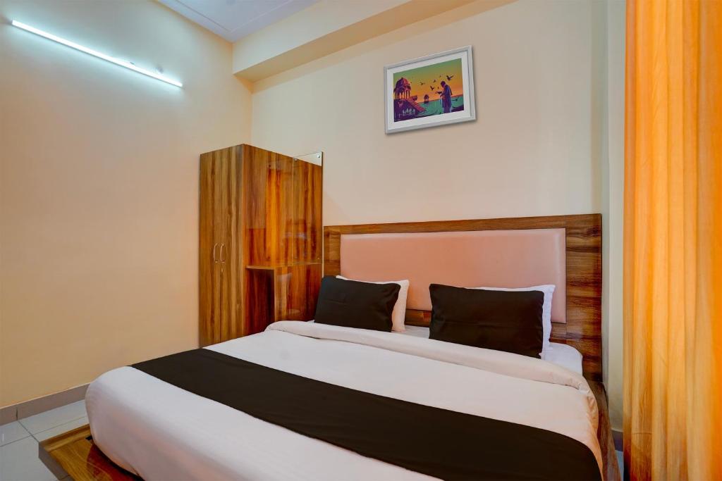 哈尔德瓦尼OYO HOTEL STAY INN的一间卧室配有带橙色窗帘的大床