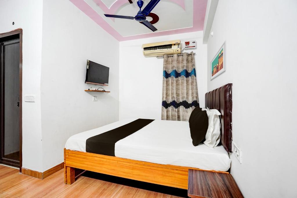 兰纳加OYO Premier Jim Corbett Home Stay的一间卧室配有一张床和一台电视。