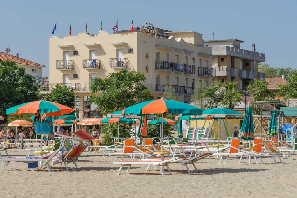 里米尼城堡酒店的沙滩上的一把椅子和遮阳伞