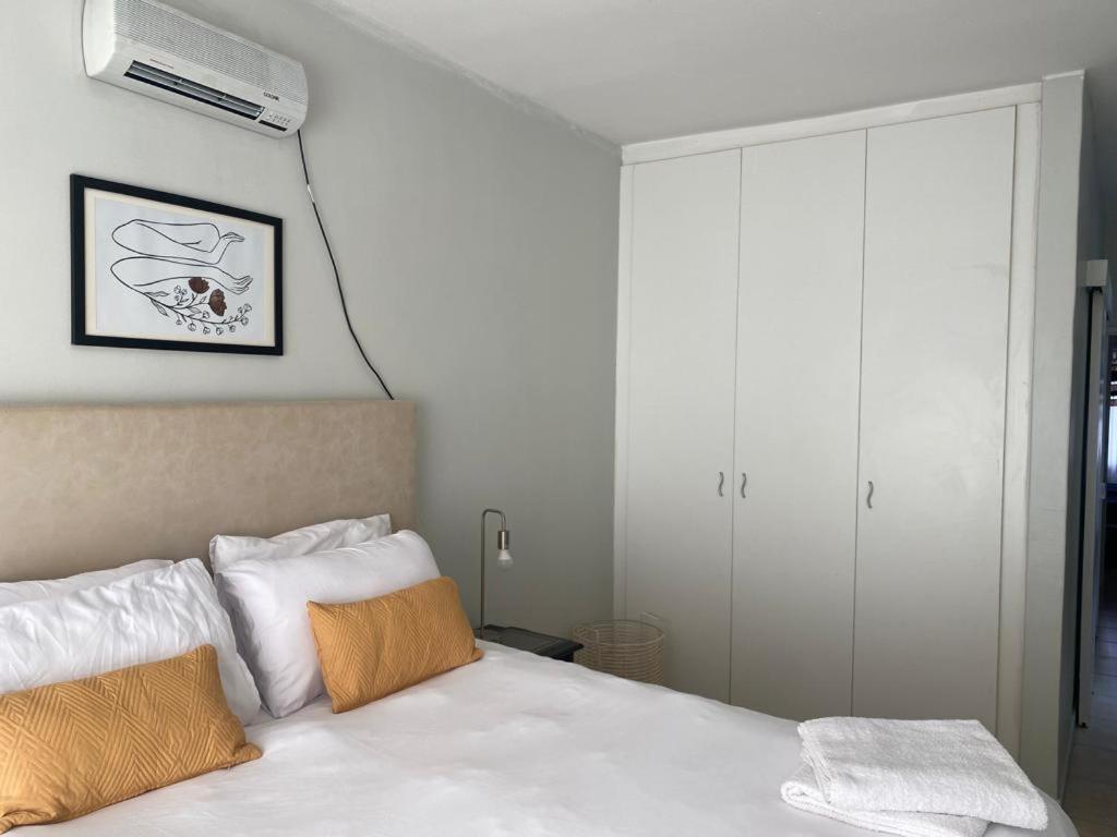 LangstrandSt Chris Villa 2的卧室配有白色床,墙上配有空调