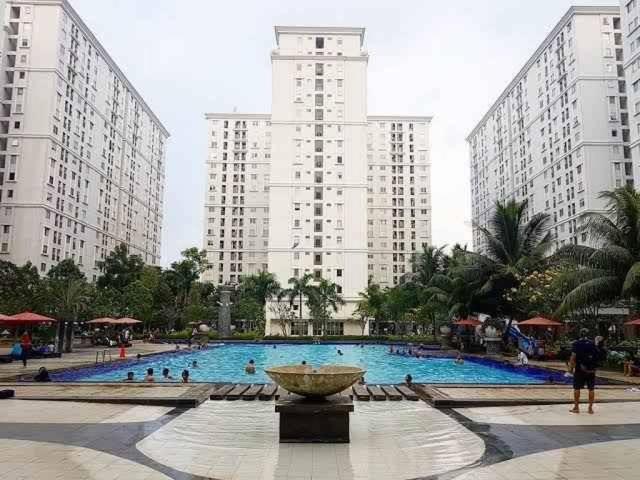雅加达OYO 93857 Apartemen Kalibata City By Artomoro的一座大型游泳池,在高楼前设有喷泉