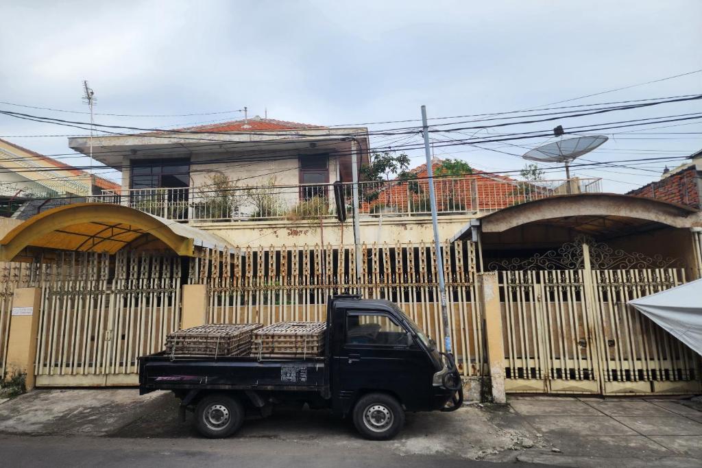 泗水OYO 93863 Dv Homestay Syariah Genteng的停在栅栏前的一辆黑色卡车